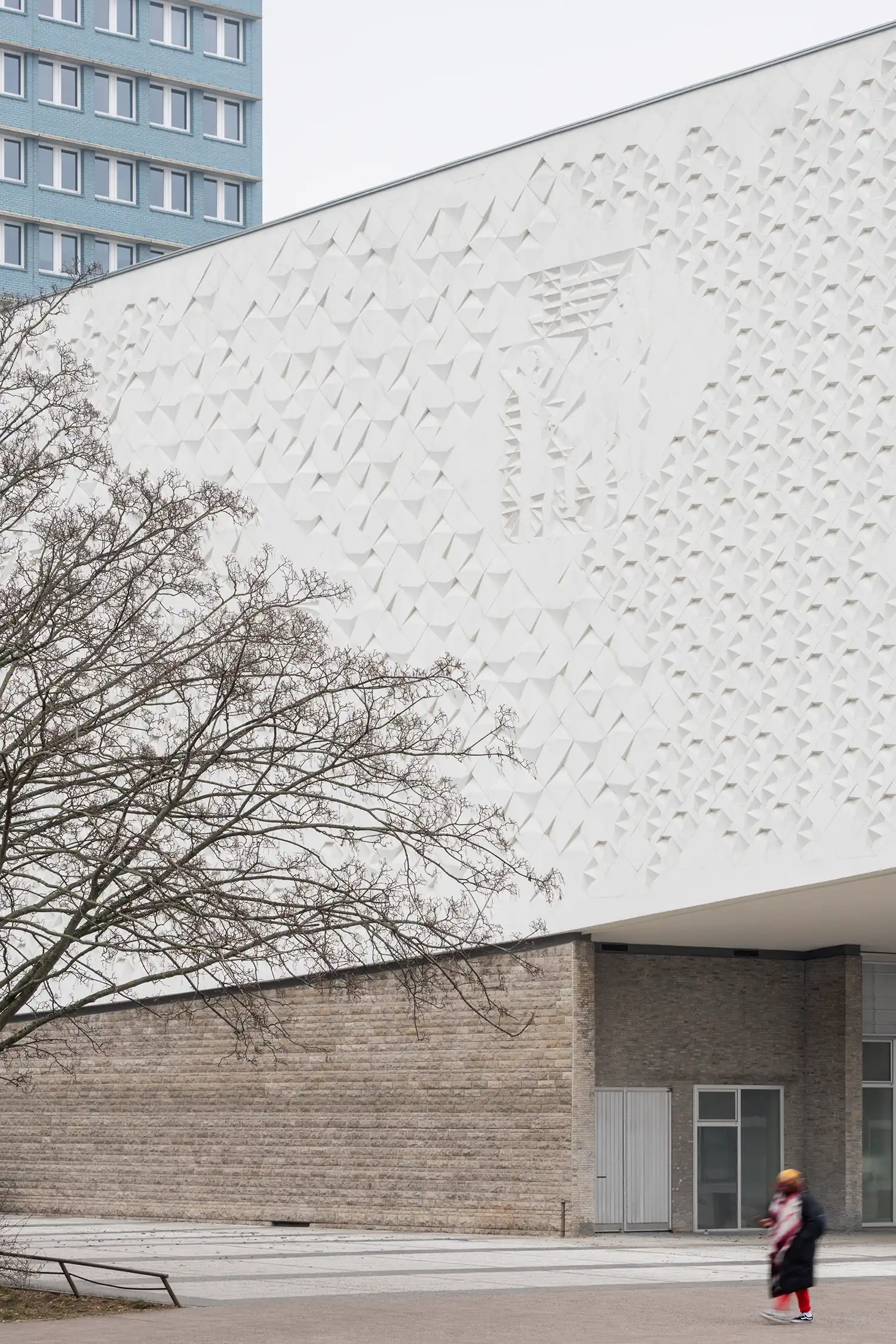 Detail of the white textured relief on the side facade of the Kino International building.