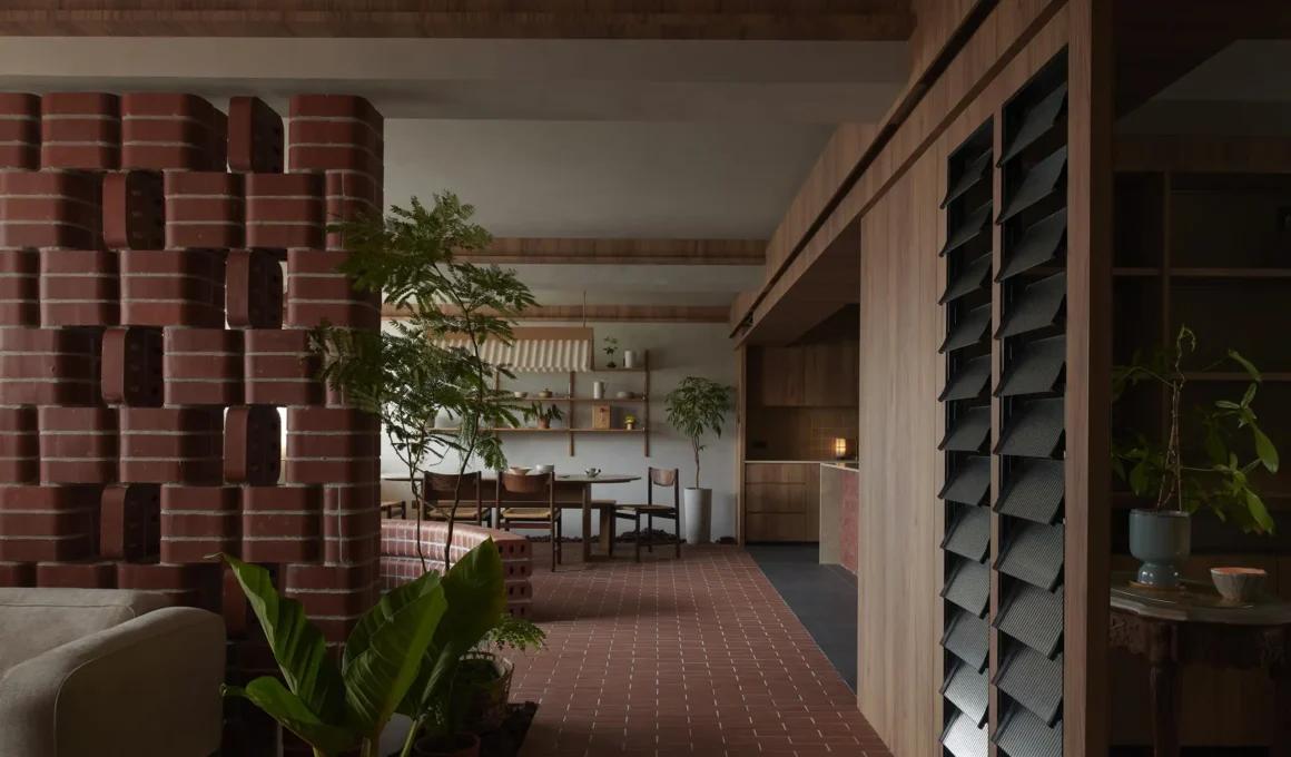 Open-plan interior of In a Park apartment in Singapore with red brick flooring and partition.