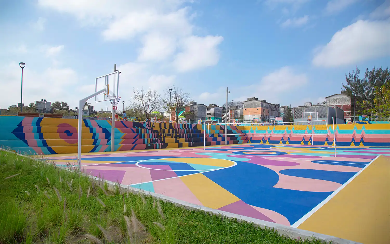 Colorful concrete bleachers and basketball court at La Bulla park.