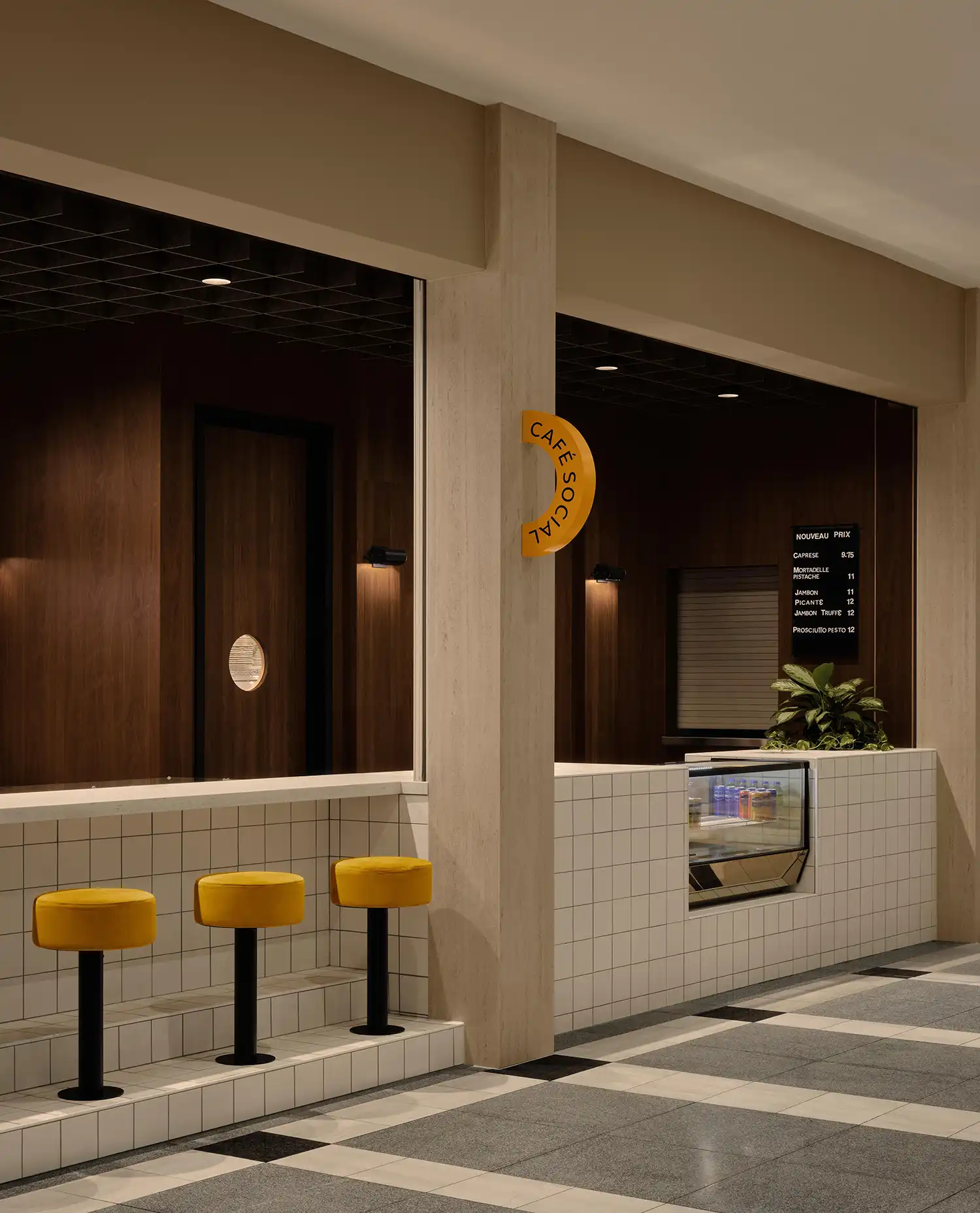 Café Social counter in Longueuil with white grid tiling and yellow velvet stools