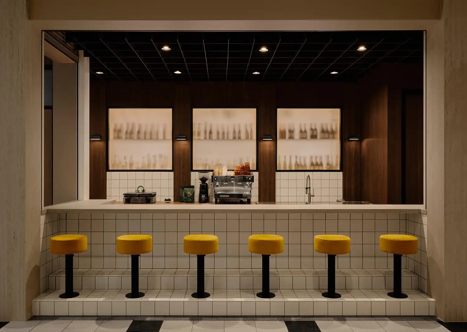 Symmetrical view of the Café Social bar with dark wood and three frosted glass windows