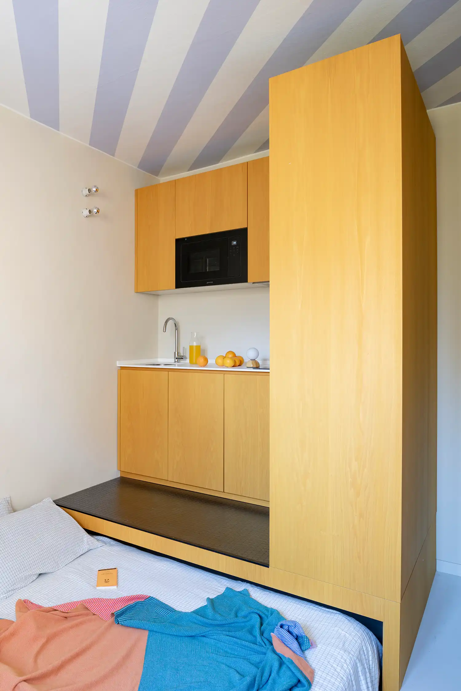 Detail of retractable bed and integrated kitchen in Milan micro-home