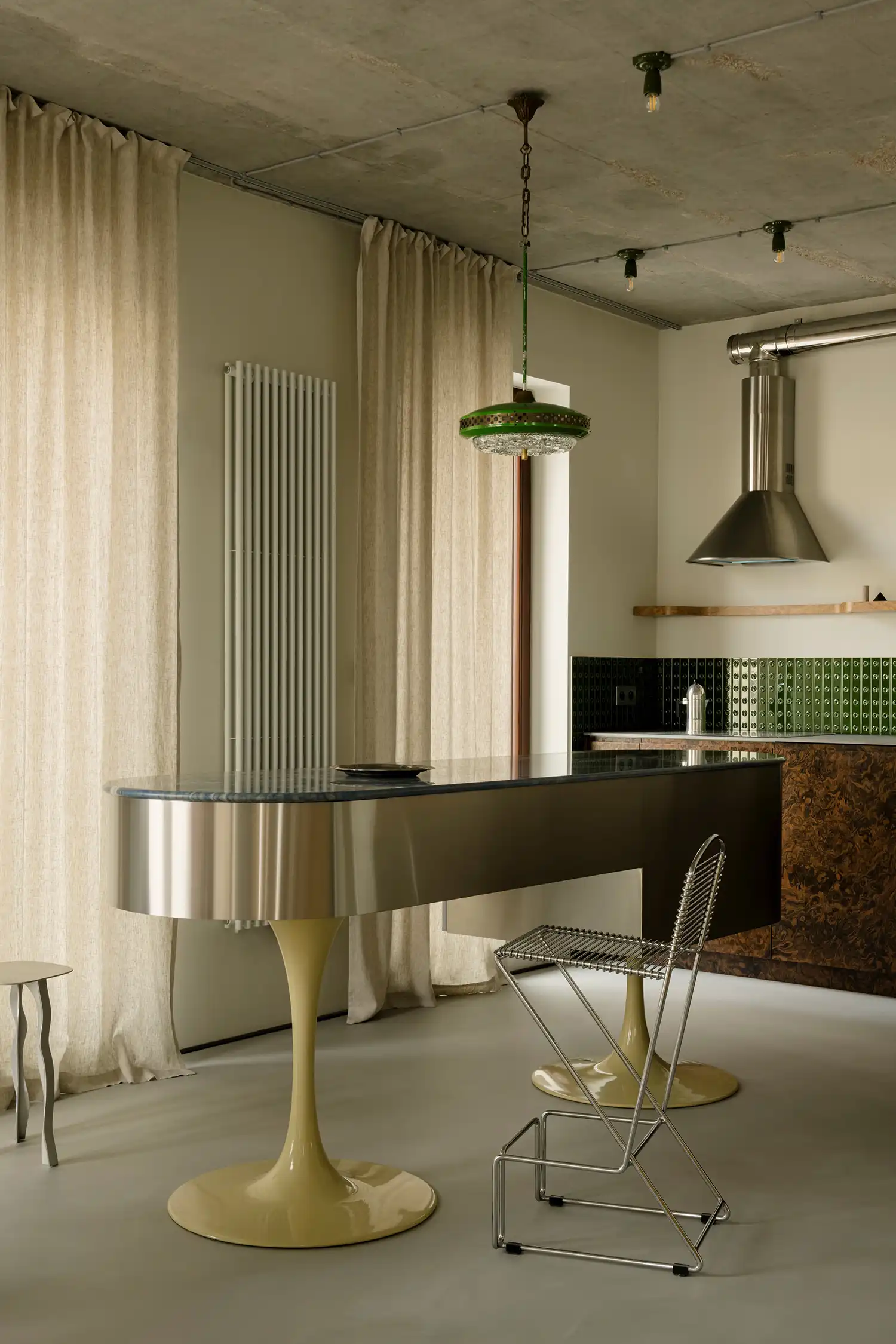 Futuristic steel kitchen island with green vintage pendant lamp