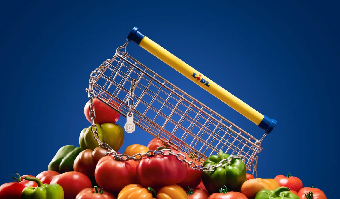 Conceptual view of the Lidl x Nik Bentel Trolley Bag resting on a pile of fresh vegetables against a deep blue background.