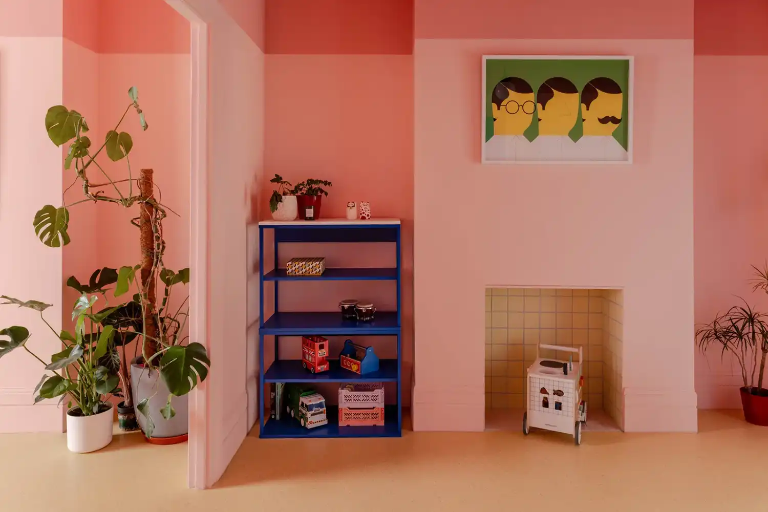 Interior room with dual-tone pink walls, a blue shelving unit, and a tiled fireplace nook.