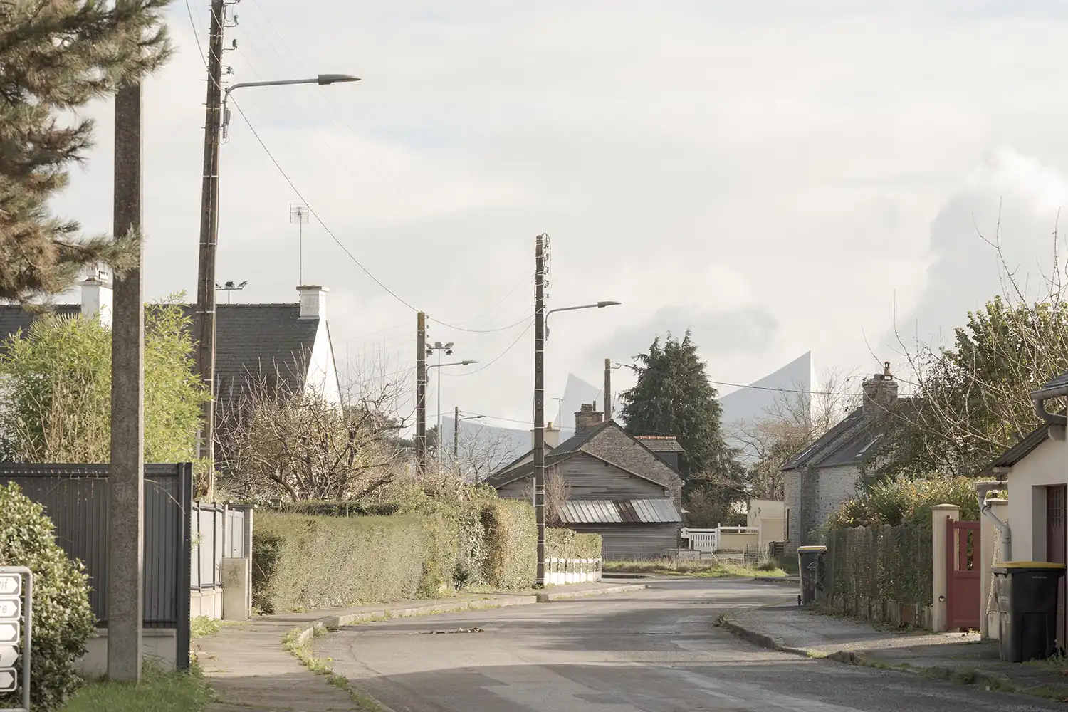 The white peaks of the sports center visible above a residential street in France.