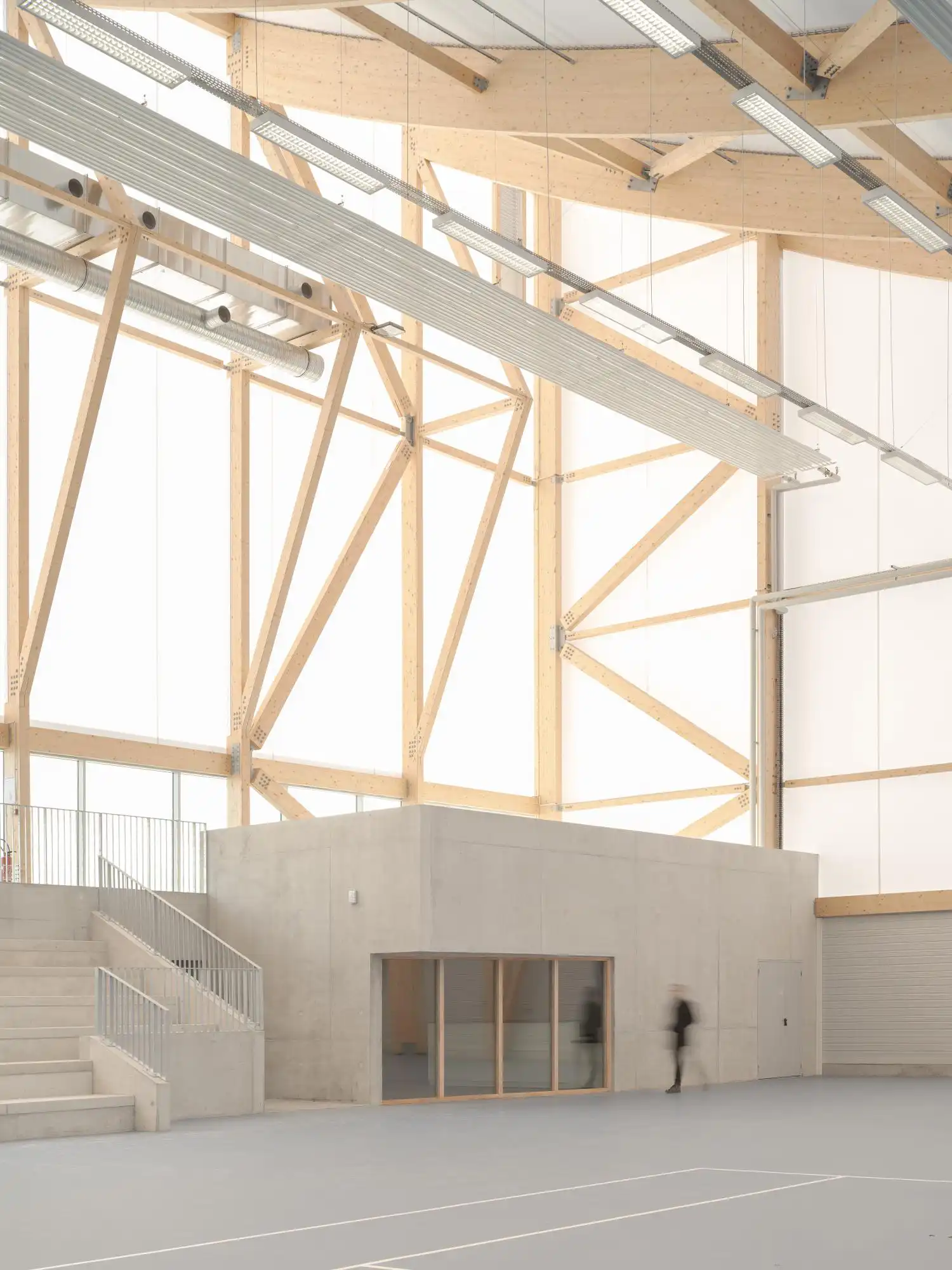 View of concrete social areas within the timber-framed sports hall.