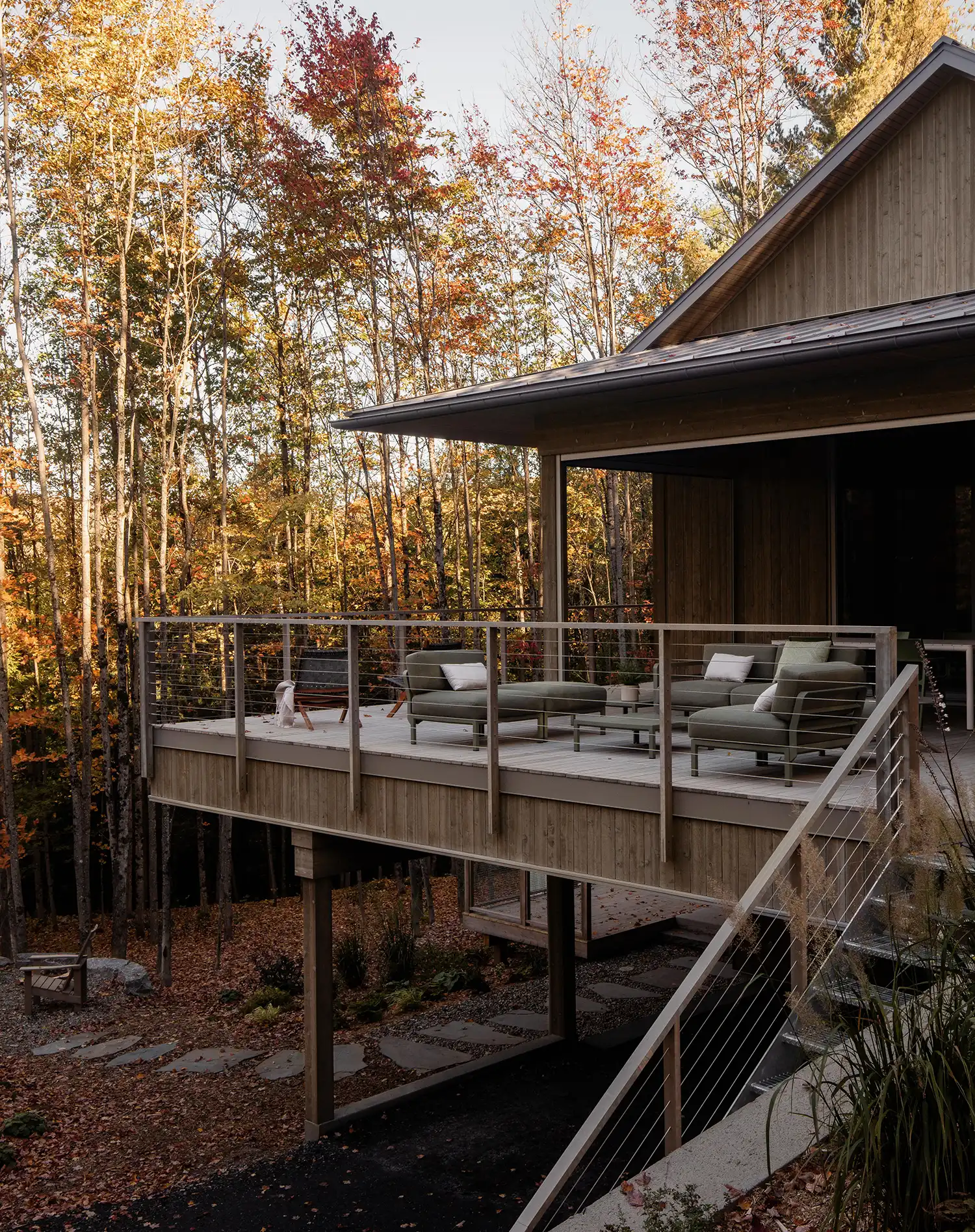 Close-up of the cantilevered wooden deck with modern outdoor furniture at Perchée house.