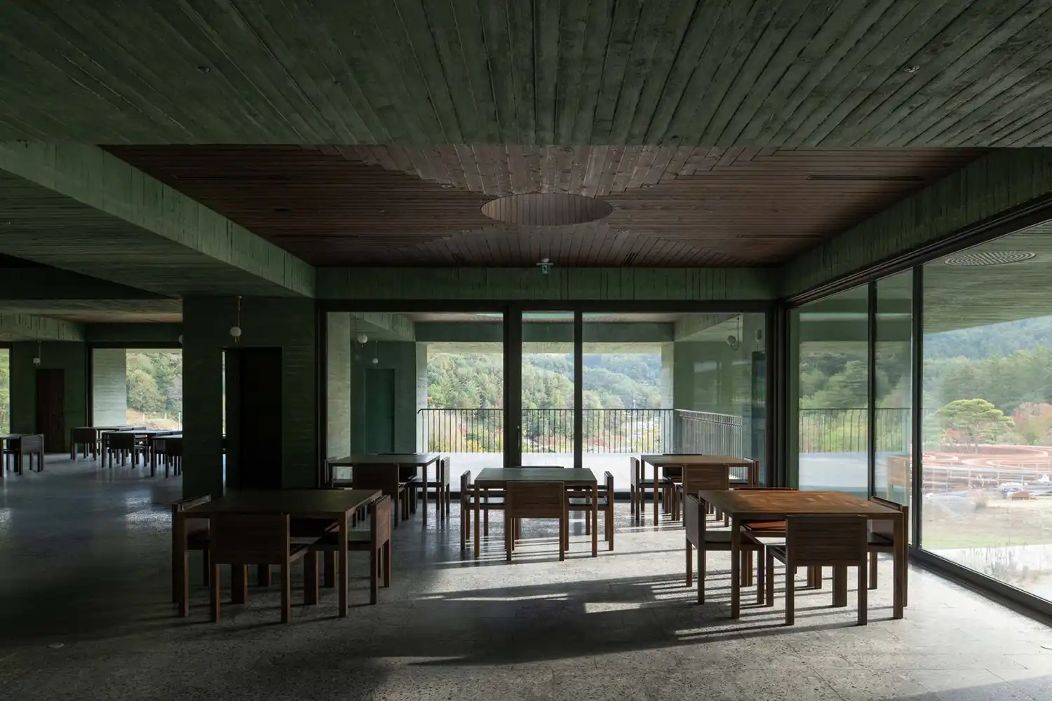 Minimalist dining room interior with oak ceilings and floor-to-ceiling glass walls