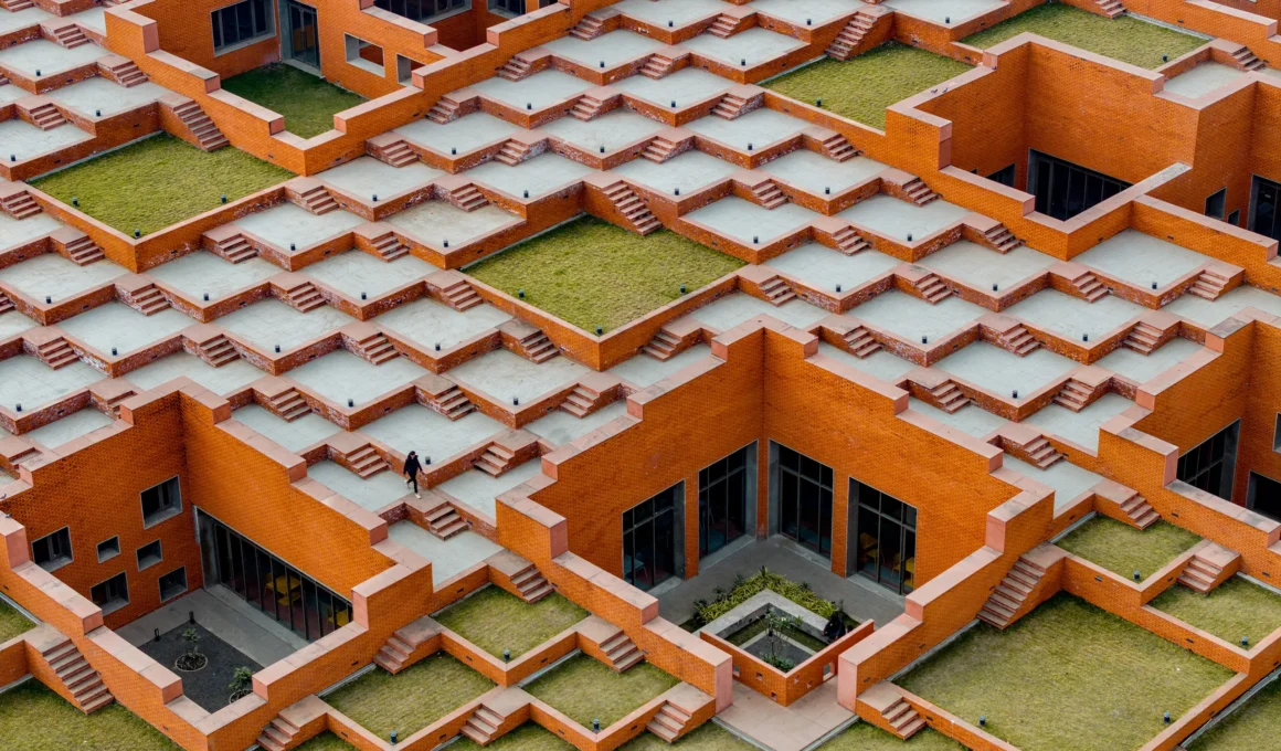 Aerial view of the stepped red brick roof terraces at Prestige University.