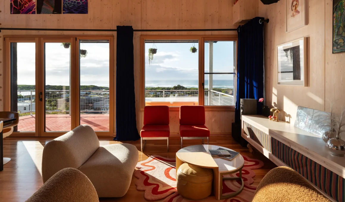 Cozy interior living room of a Passivhaus in Tasmania with ocean view through large windows.