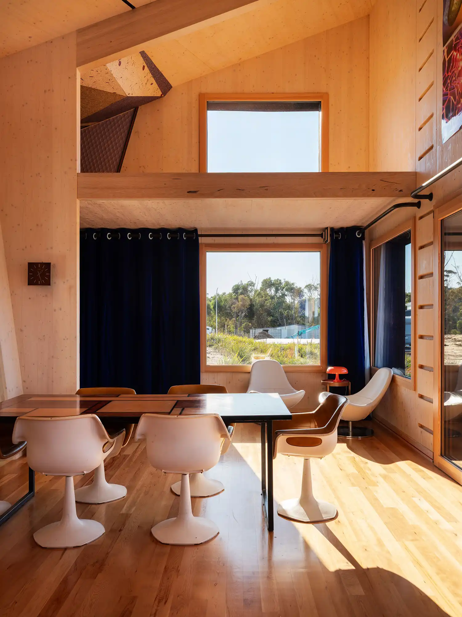 Modern dining area inside the Tasmanian coastal home with large windows looking out to nature.