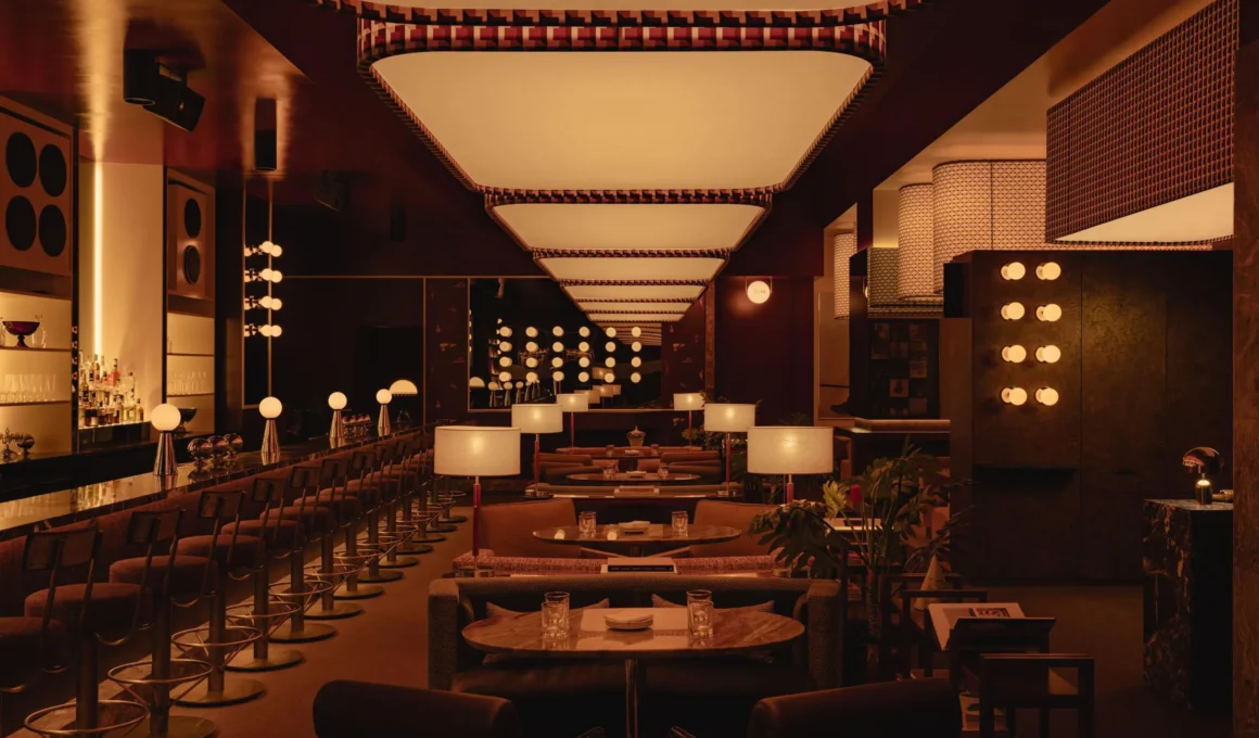 Interior of Mimi in Edmonton featuring a long bar, custom velvet seating, and a rhythmic ceiling lighting installation.