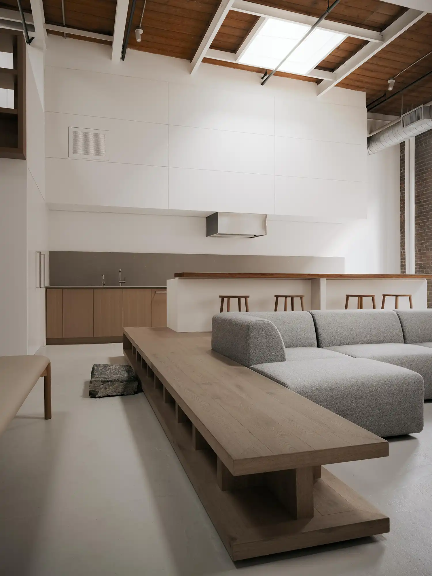 Integrated oak platform and gray modular sofa by StudioAC