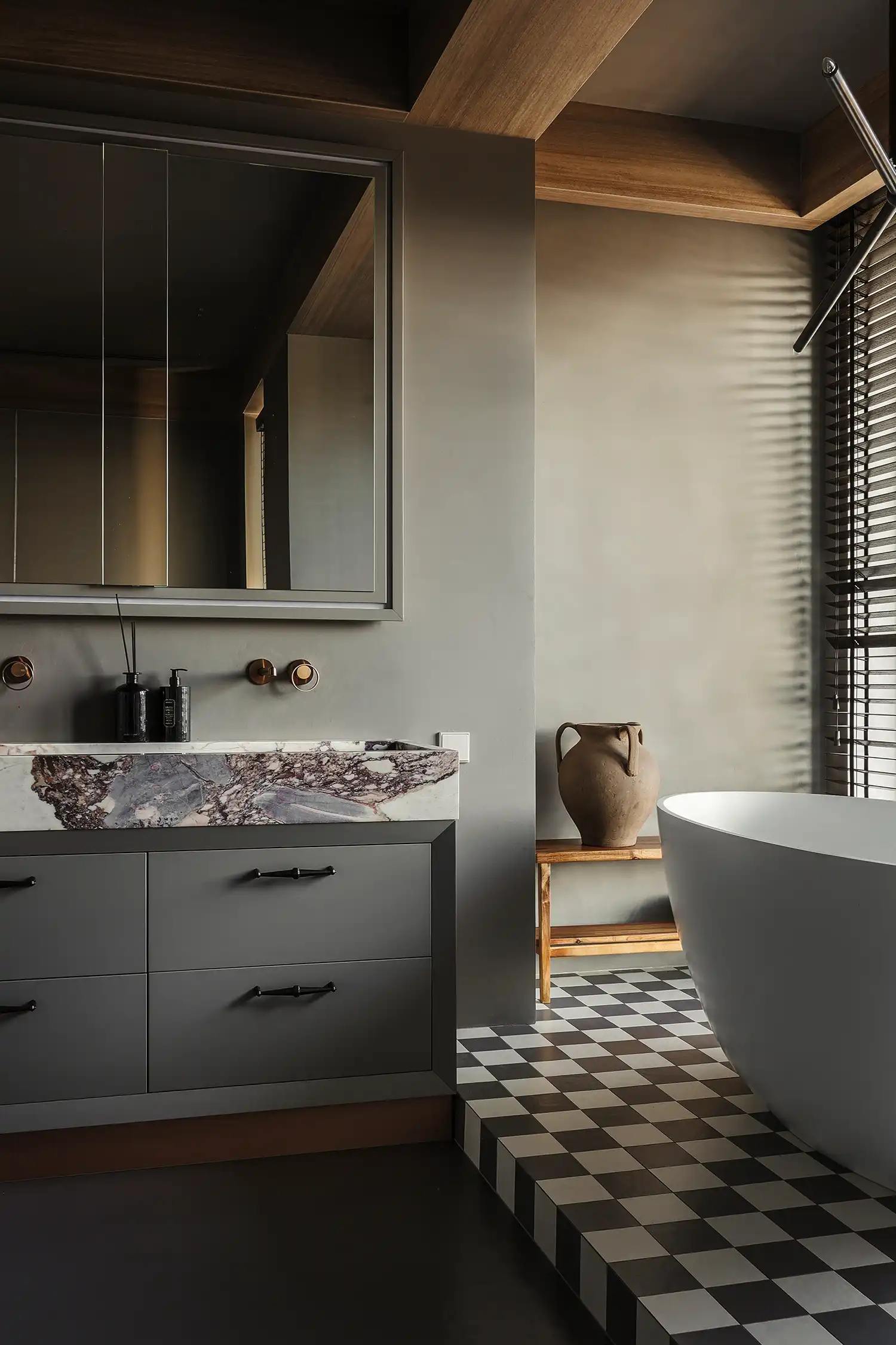 Luxury bathroom with checkered floor, Calacatta Viola marble sink, and freestanding tub.