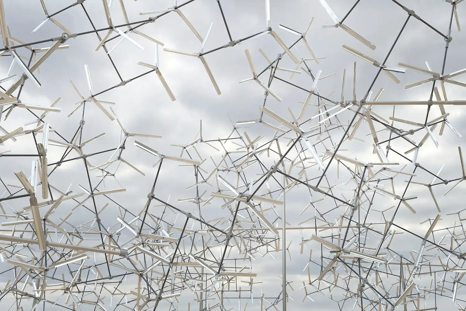 Low-angle view of the Fractal Swarm sculpture against a gray sky.