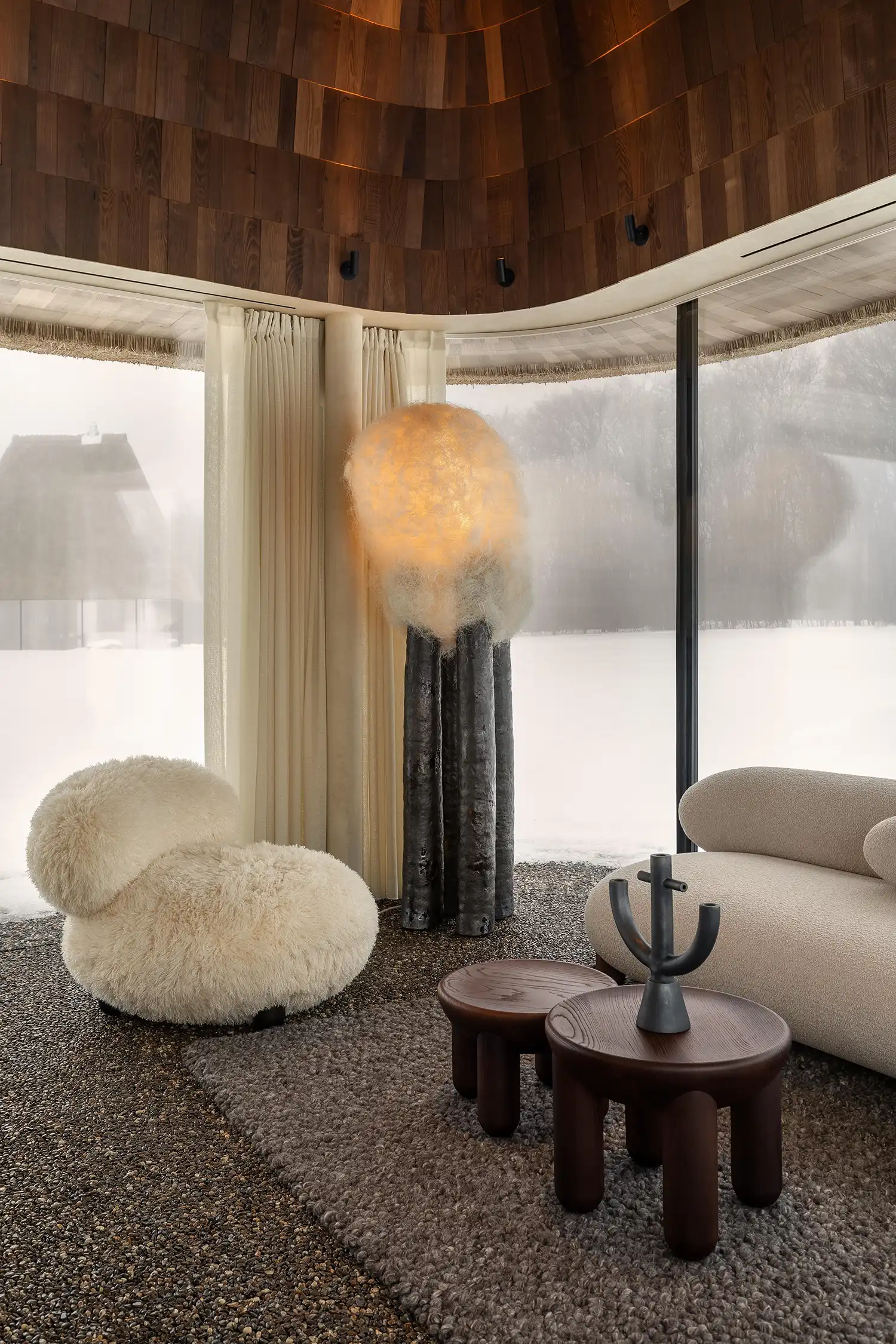 Eco-minimalist interior with bouclé furniture and a sculptural glowing lamp.