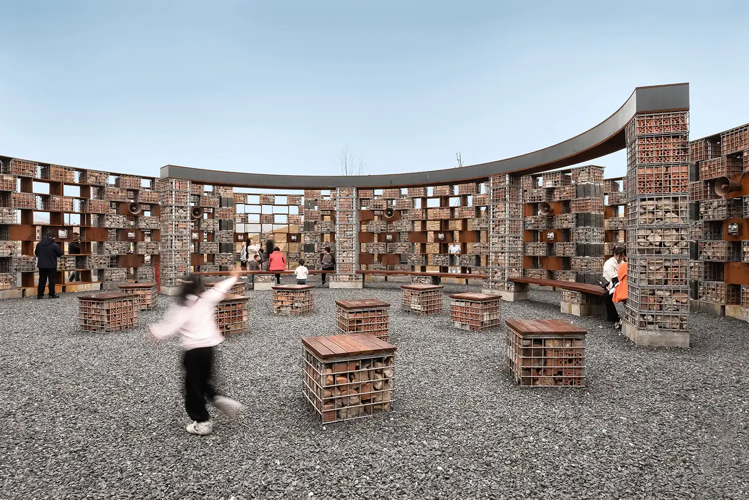 The central Echo Plaza amphitheater with gabion benches and people gathered in the open-air space.