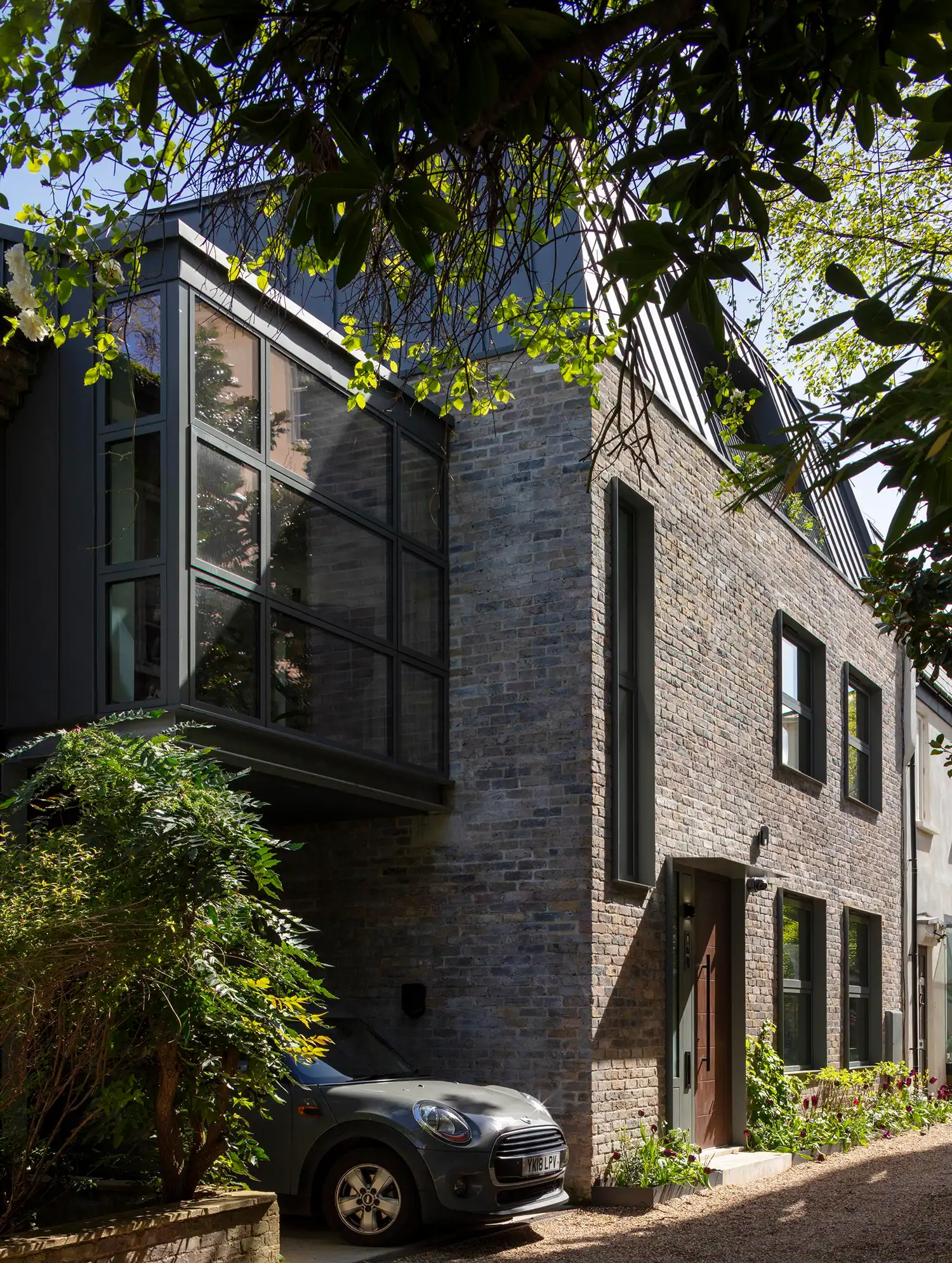 Exterior of a London brick terrace with a modern zinc and glass cantilevered extension.