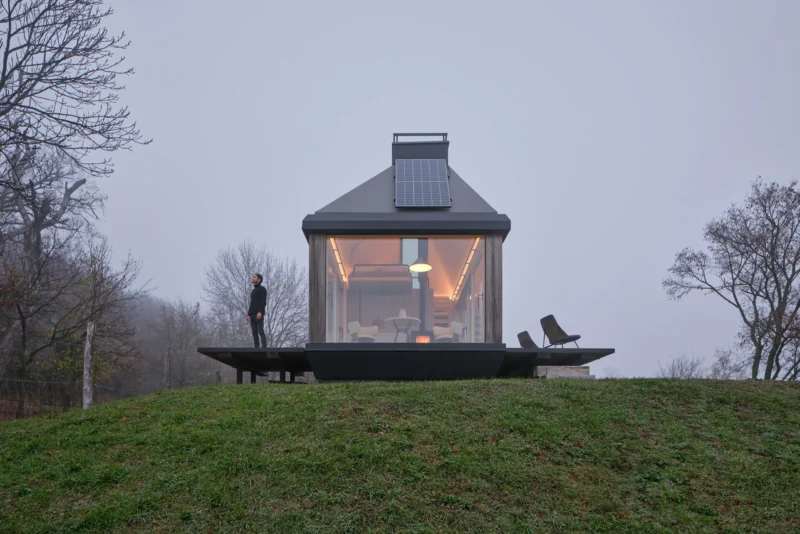 Exterior view of Cabin Devín by Ark-Shelter on a misty hill in Slovakia.