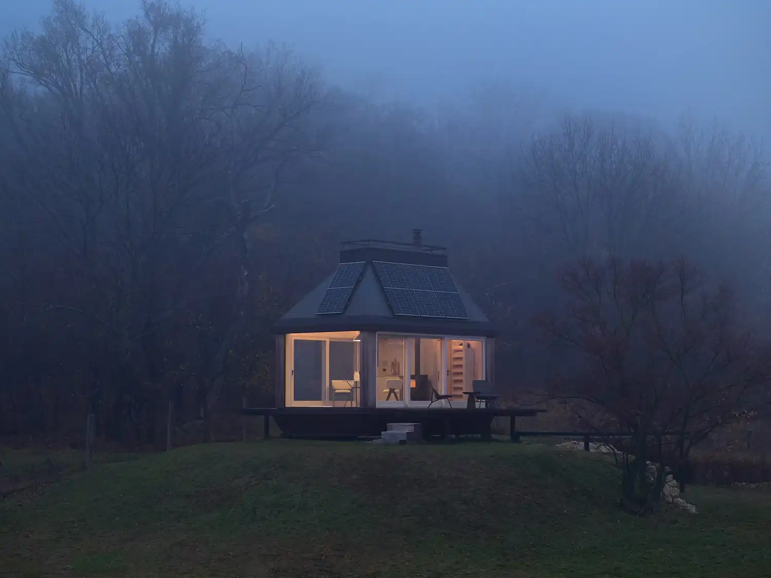 Cabin Devín glowing at dusk amidst the mist in a Slovakian vineyard.