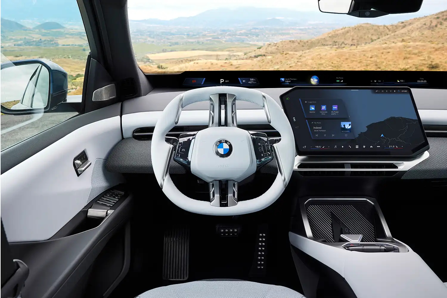 Frontal view of the BMW iX3 dashboard featuring the full-width Panoramic Vision display.