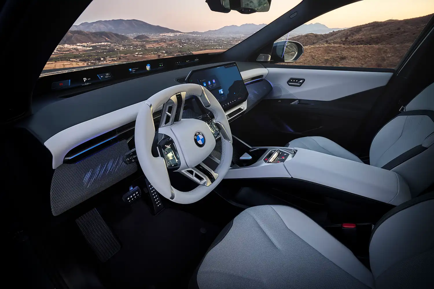 Interior of the BMW iX3 at dusk showing ambient lighting and Panoramic Vision.