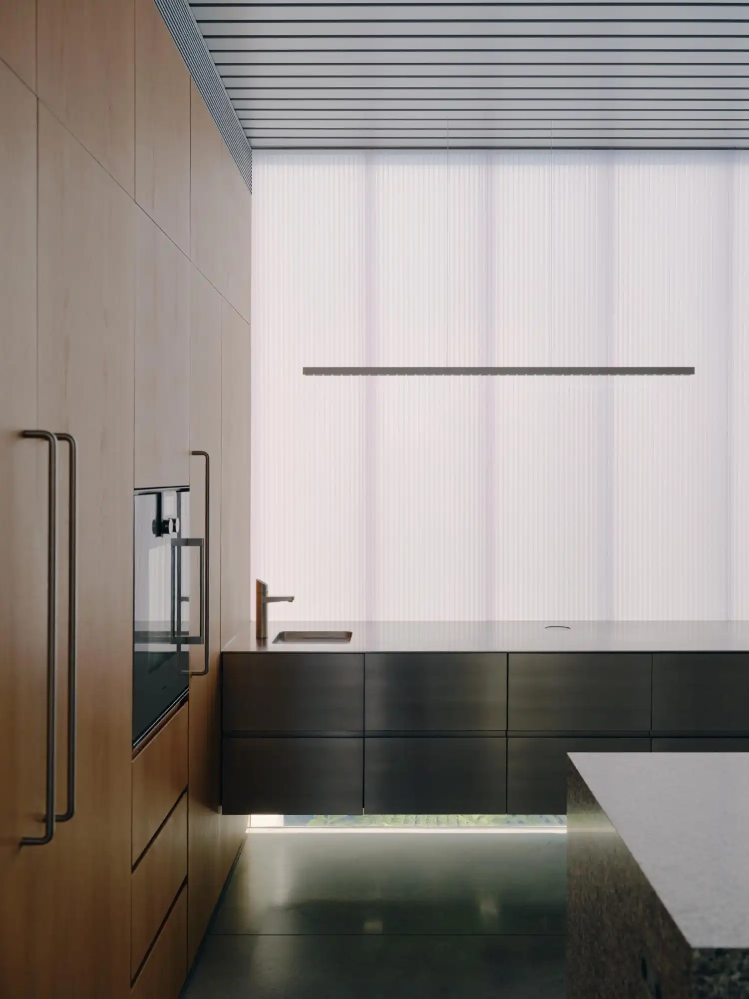 High-end kitchen with stainless steel cabinetry, a minimalist island, and warm wood storage walls.