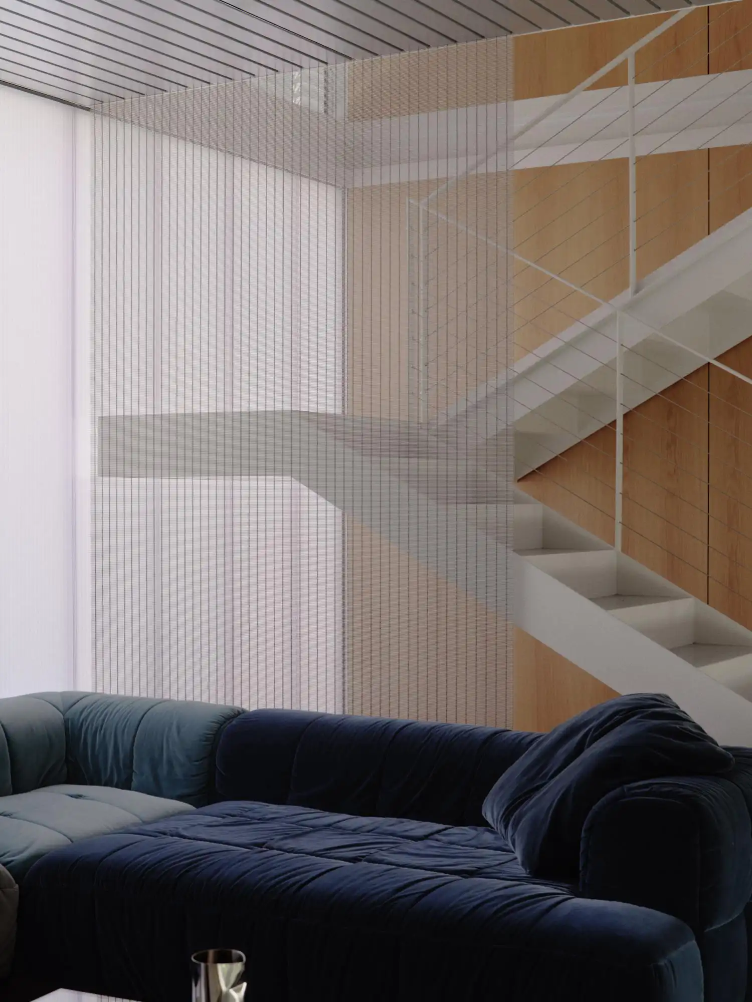 Detail of a white perforated metal staircase next to a navy blue velvet modular sofa.