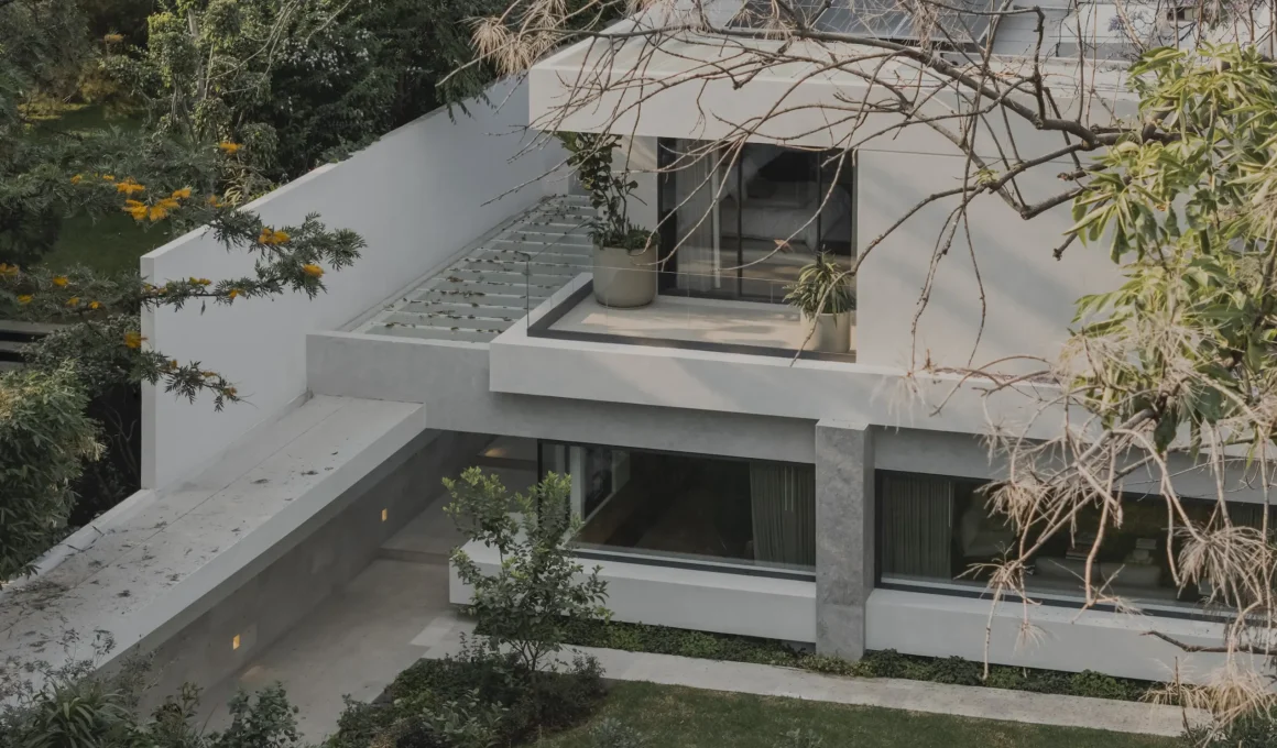Aerial view of CDLA House in Mexico City featuring white geometric volumes and integrated garden.