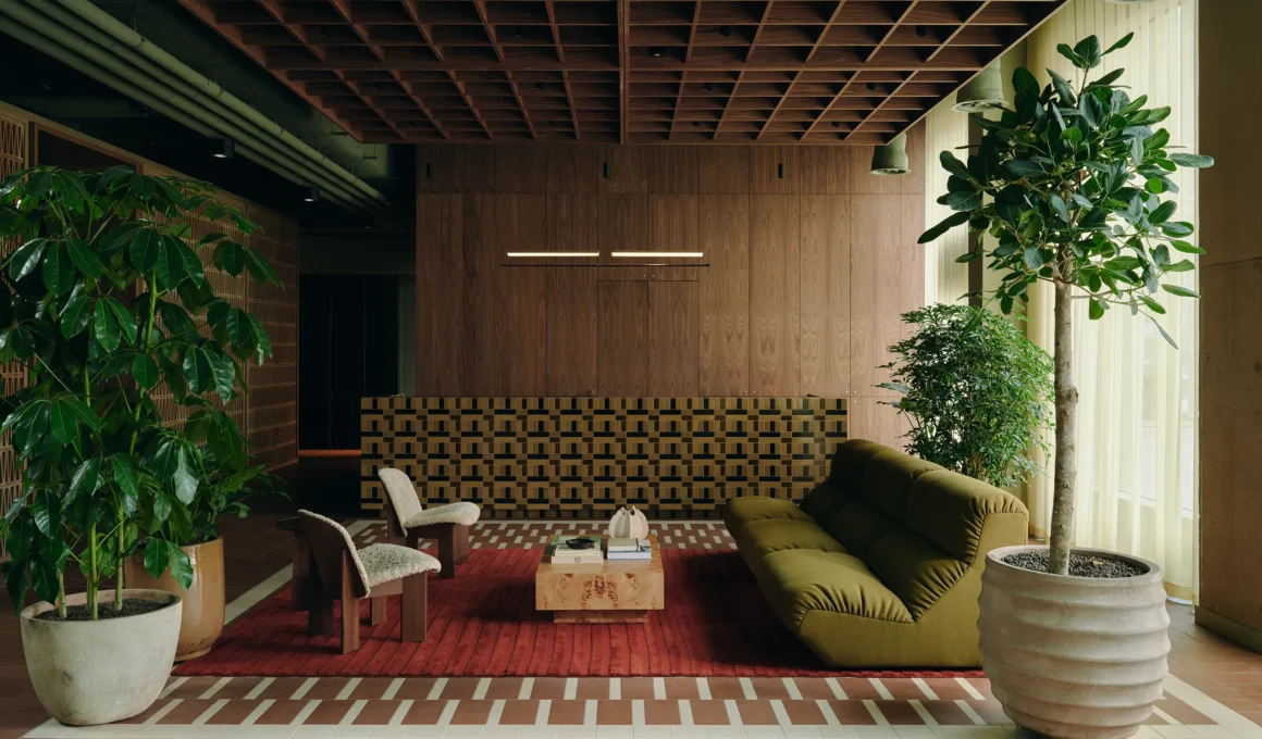 Reception area with wood coffered ceiling, terracotta floors, and mid-century furniture.