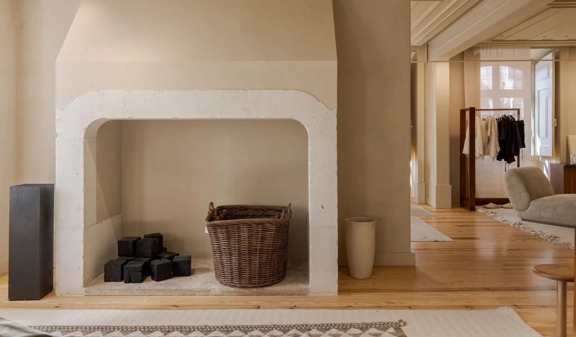 Minimalist retail interior with a restored historic stone fireplace in Lisbon