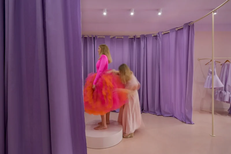 fitting a pink and orange dress on a platform