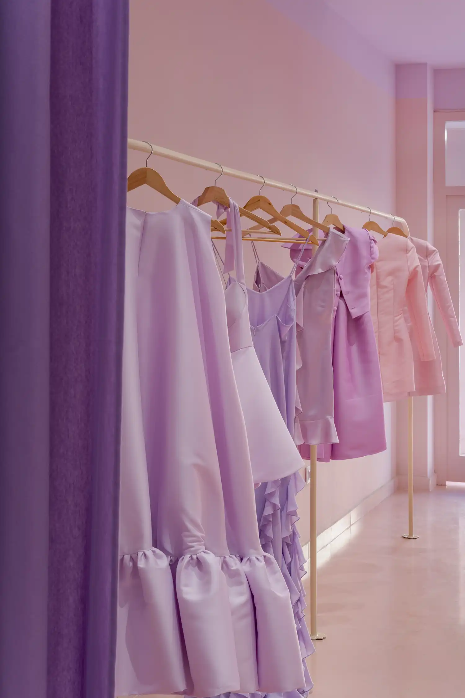 purple and pink dresses on a white rack