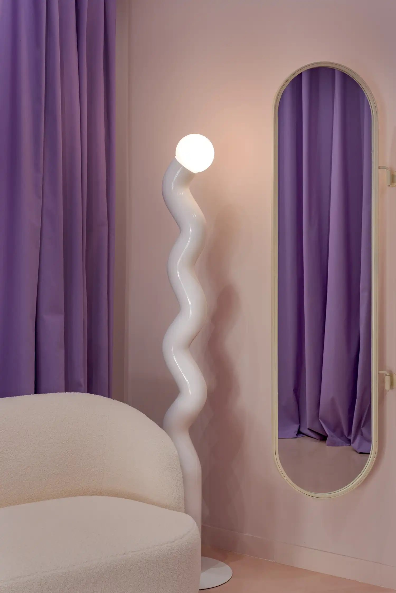 curved lamp and mirror in a purple and pink room
