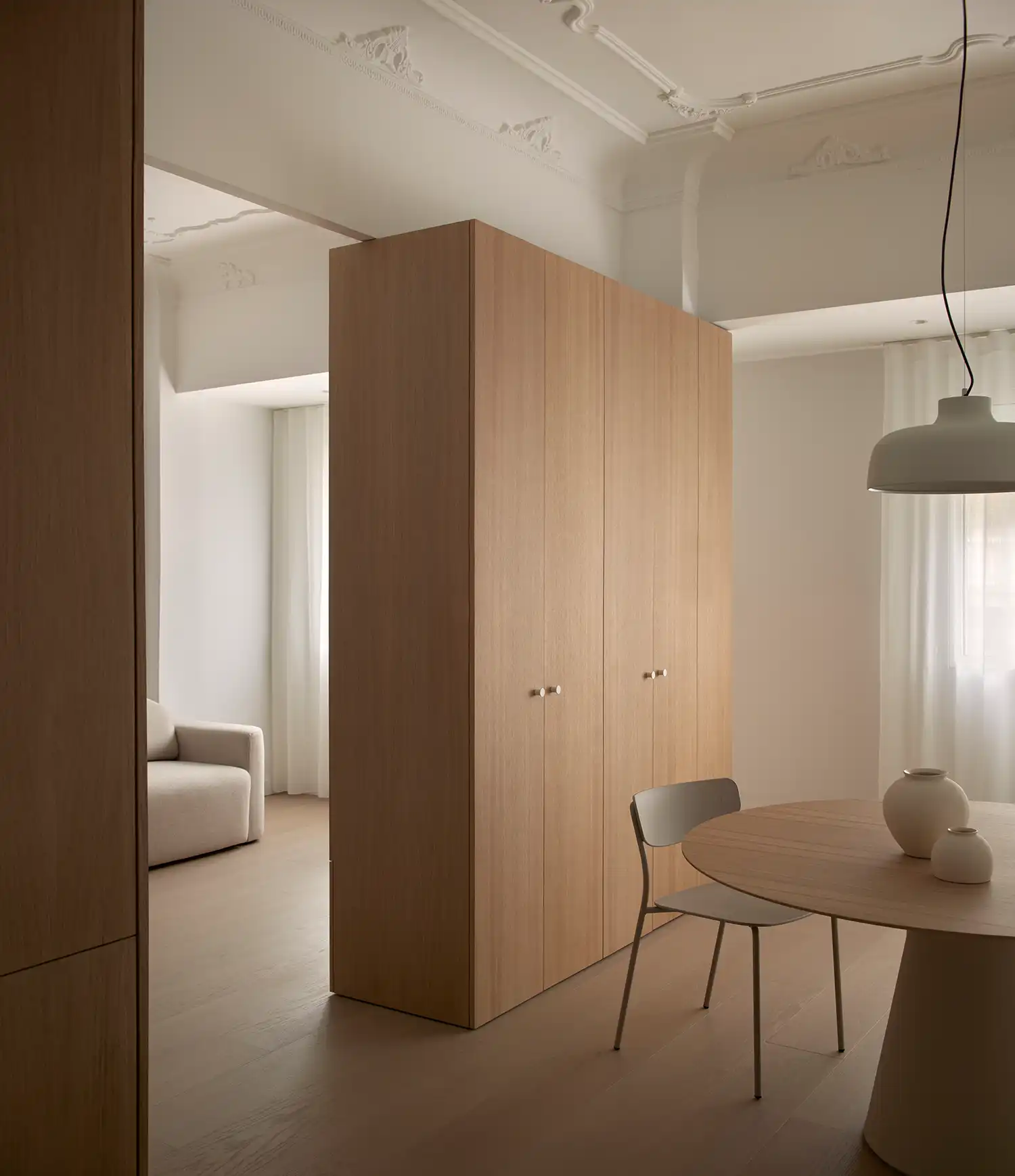 Floor-to-ceiling oak storage volume structuring the open-plan layout of Casa Zam 12.