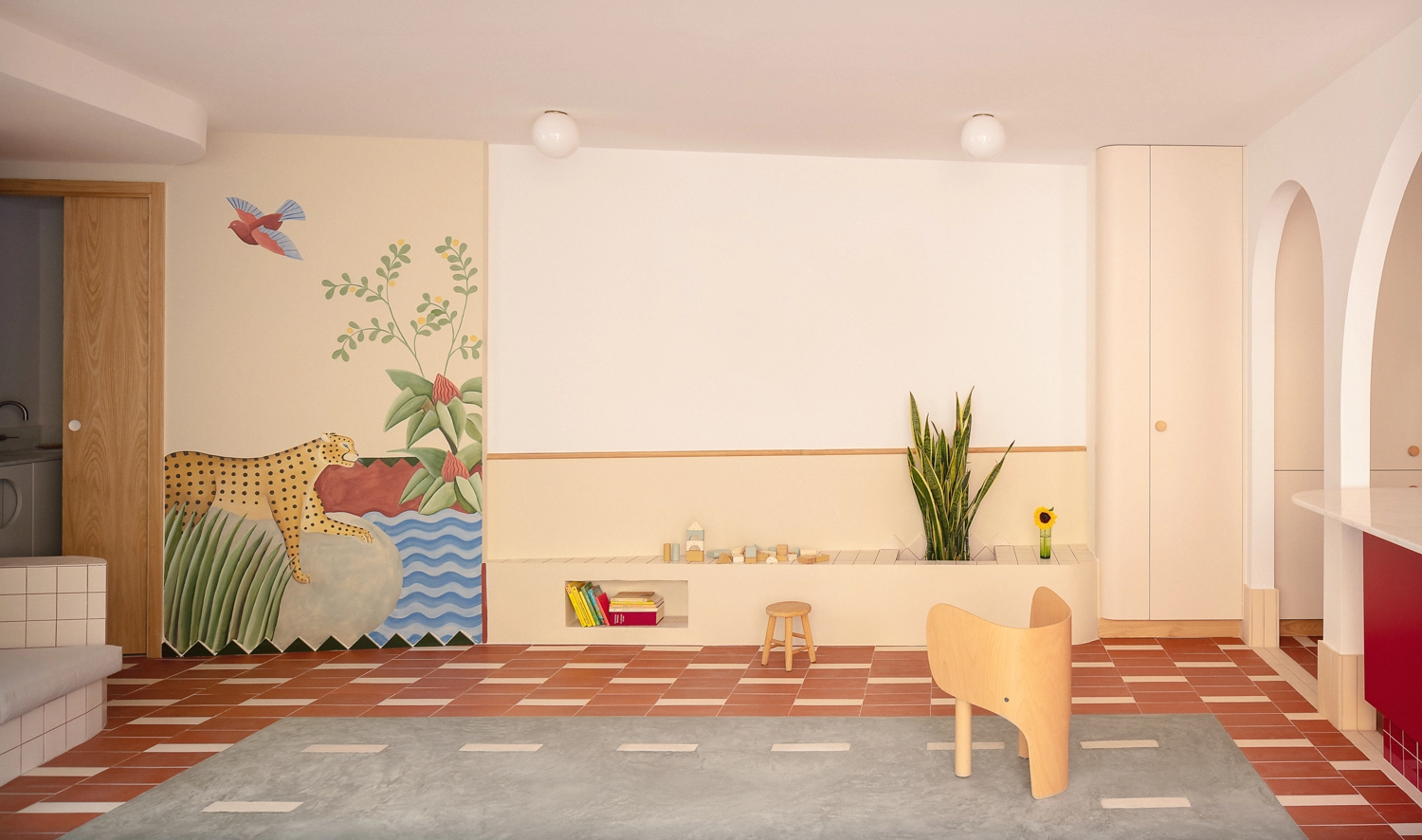 A large colorful wall mural featuring a leopard and tropical plants next to a minimalist built-in bench in a Valencia apartment.