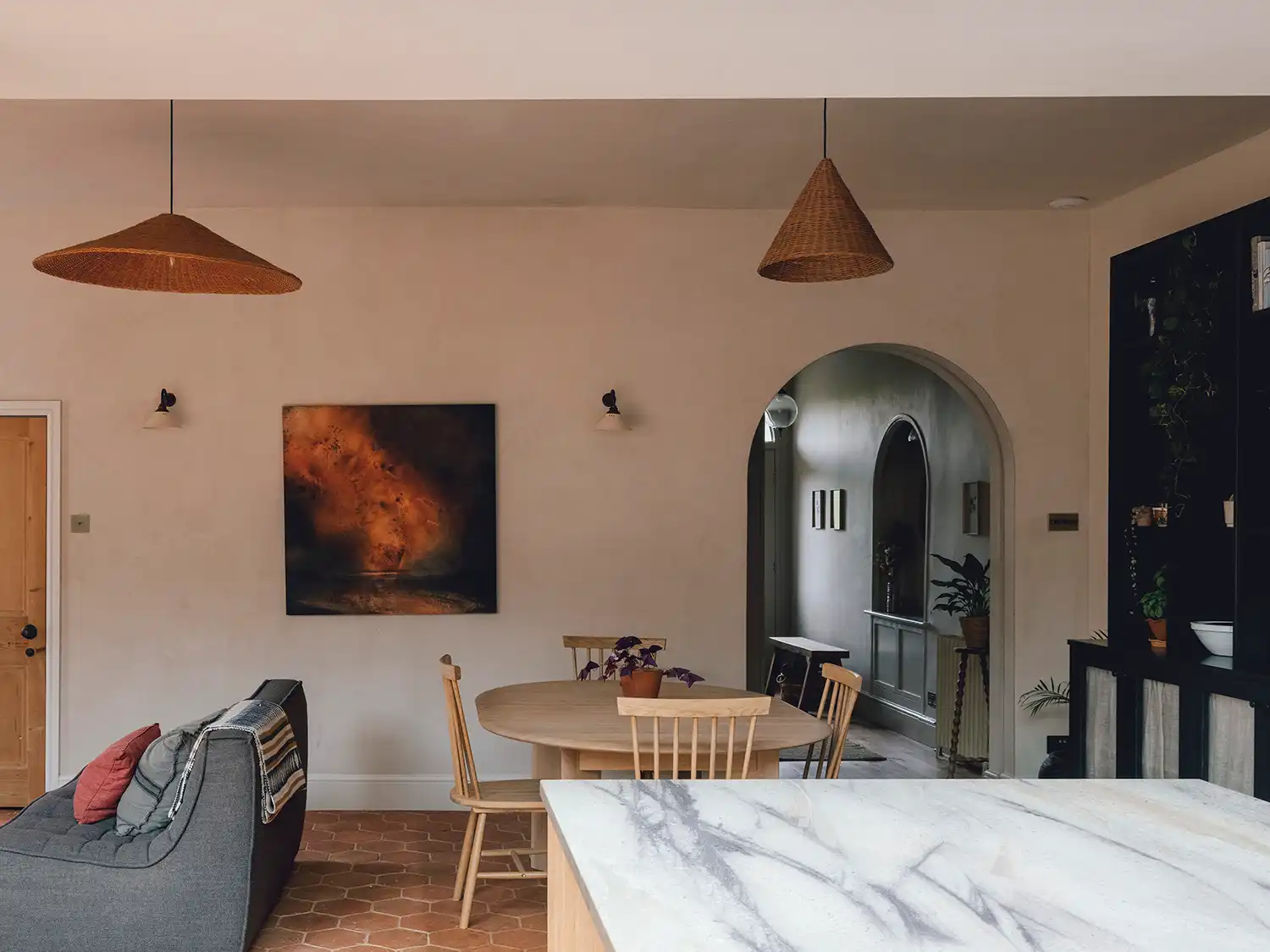 Open-plan dining and living area with an arched doorway leading to a hallway.