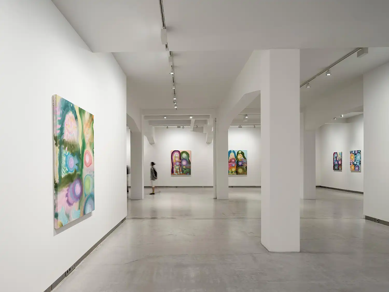 Bright white contemporary art gallery with large colorful abstract paintings on the walls.