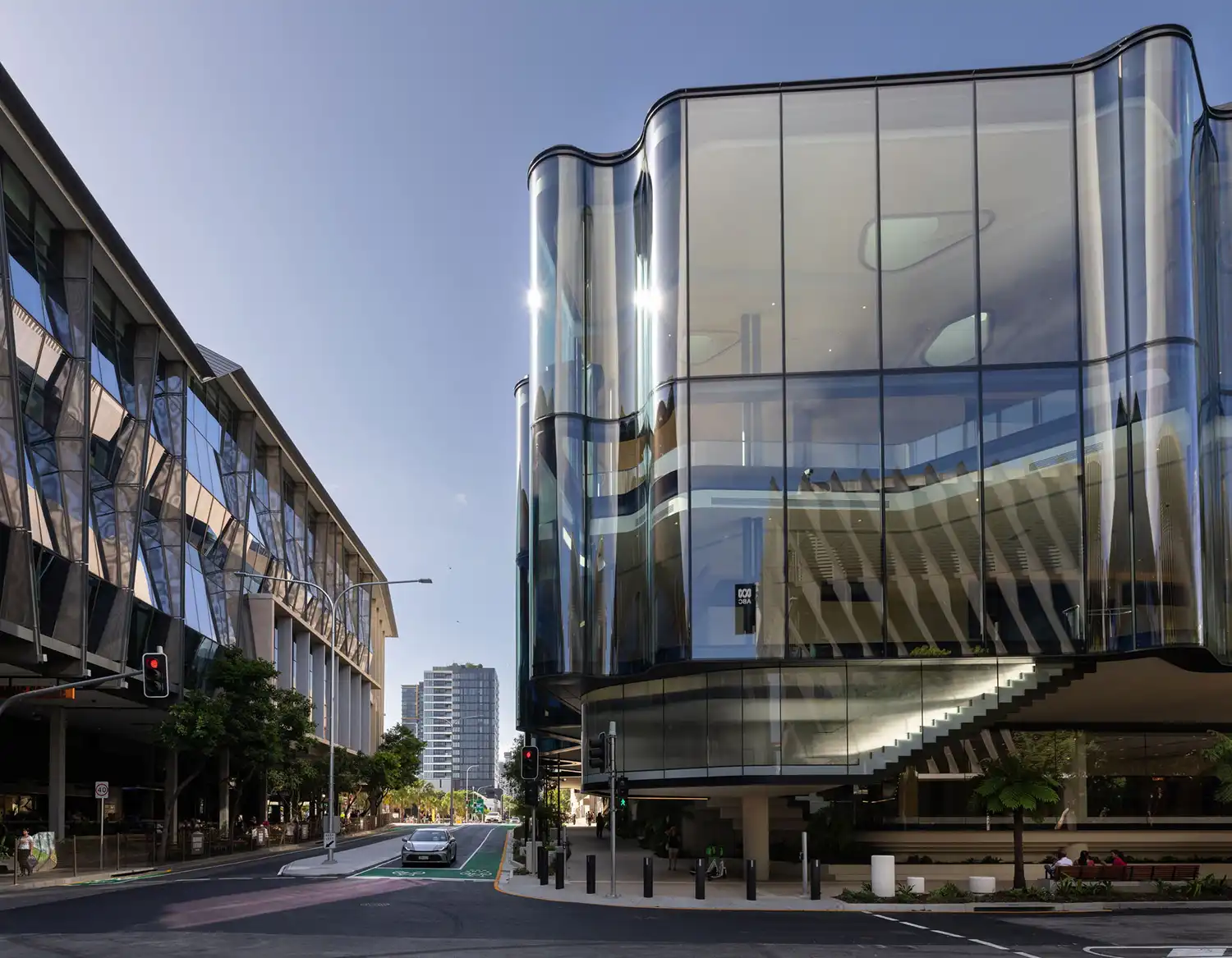 Daytime street view showing the cantilevered glass foyer of the theatre over a Brisbane sidewalk.