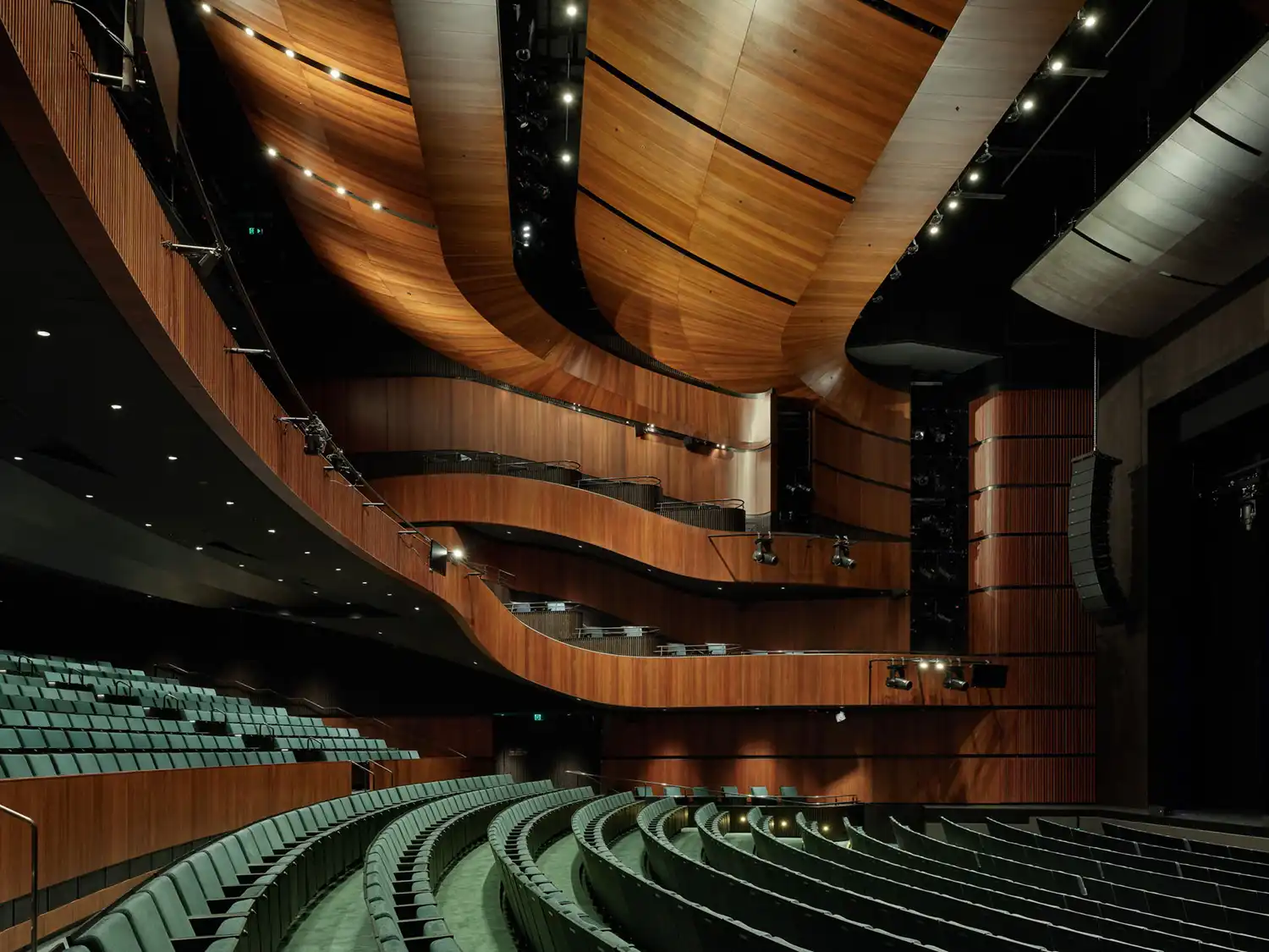 View from the rear of the auditorium showing the wrap-around timber balconies and green stalls.