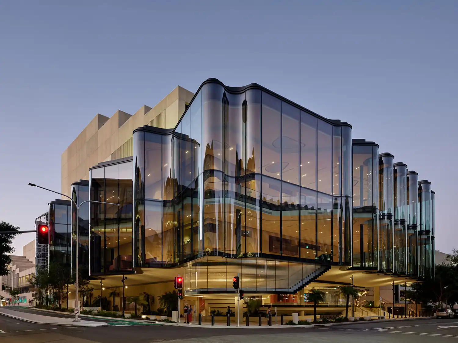 Perspective shot of the theatre at dusk, showing the relationship with the original QPAC concrete structure.