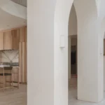 Sculpted white arches and bespoke ash kitchen cabinetry in West London House.