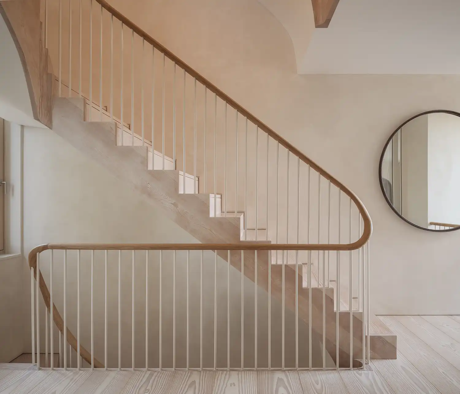 Curving timber staircase and white spindle balustrade in Stamford Brook home.