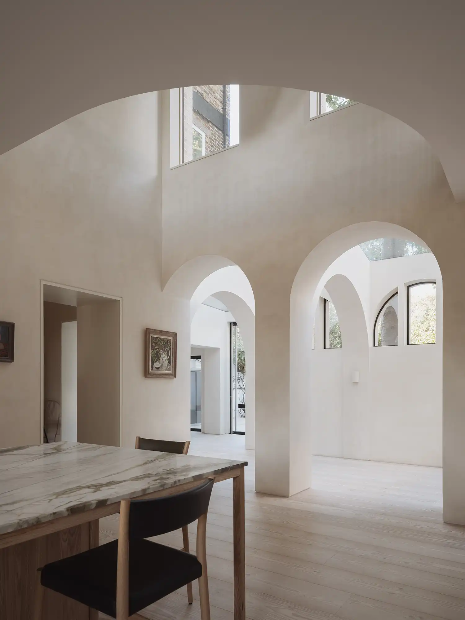 Internal view of double-height vaulted living space with arched openings.