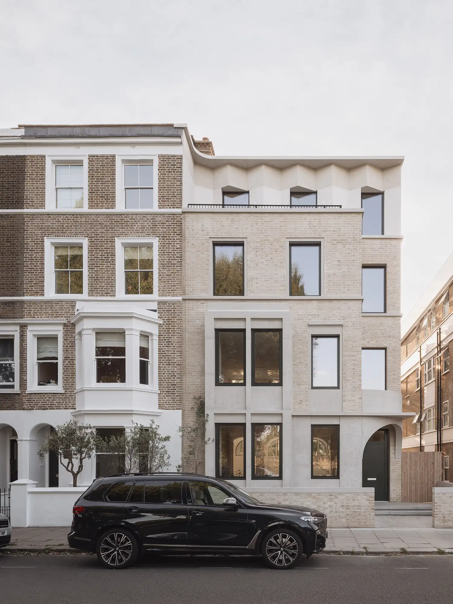 Street elevation of West London House showing the accordion-form brick facade.