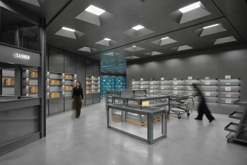 Wide view of HARMAY Beijing retail interior with industrial lighting and steel display units.