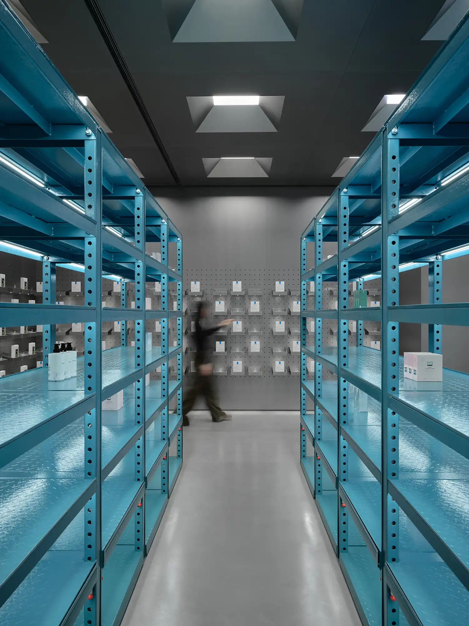 Symmetrical view of teal industrial shelving units in HARMAY Beijing beauty store.