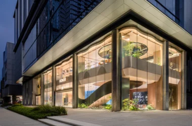 HONOR Flagship Store exterior featuring two-story curved glass facade and illuminated interior at dusk