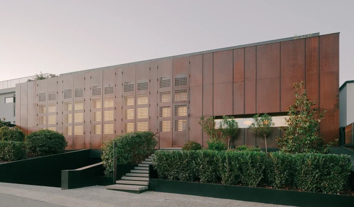 Street-facing facade of the House of Iron Doors by TIMM in Tbilisi showing the continuous weathered steel exoskeleton.